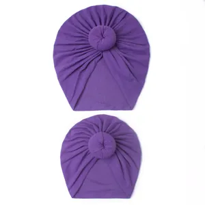 Close-up of matching purple parent-child turban hats with handmade doughnut knot detail