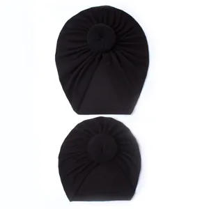 Detail of black pleated knot turbans for mother and baby in soft elastic fabric