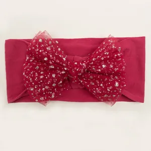 Detail of red nylon baby headband with a sparkling sequined mesh bow accessory