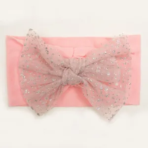 Detail of pink baby headband with a large glitter mesh bow on soft knit fabric