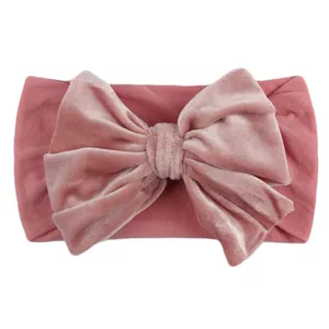 Detail of baby velvet headband with large double-layered bow in dusty rose color