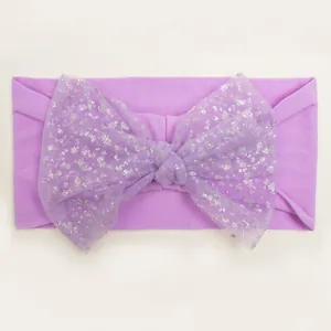 Detailed shot of purple nylon baby headband featuring a sparkling silver sequin mesh bow