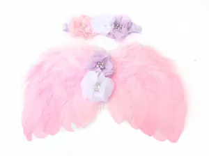 Dettaglio di ali di piuma rosa e fascia floreale per set fotografico per neonati