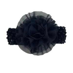 Détail d'une fleur en mousseline noire sur un bandeau extensible au crochet pour bébé