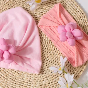 Détails d'un ensemble turban et bandeau rose pour bébé avec fleurs en tissu 3D