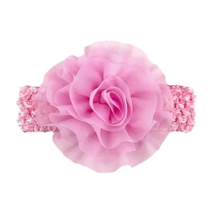 Vue détaillée de la fleur en mousseline rose et texture crochet du bandeau pour bébé
