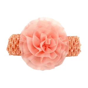 Détail d'un bandeau bébé avec fleur en mousseline et crochet élastique souple