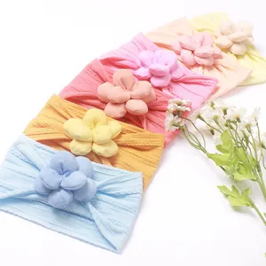 Détail de bandeaux bébé en nylon souple en six tons pastel avec des fleurs en tissu 3D