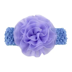 Détail d'un bandeau bleu au crochet avec une grande fleur en mousseline pour bébé