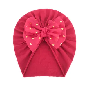 Detailansicht der babyrosa Turbanmütze mit großer goldgepunkteter Chiffonschleife