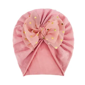 Detailierte Textur der rosa Baby-Turban-Mütze mit großer goldener Polka-Dot-Schleife