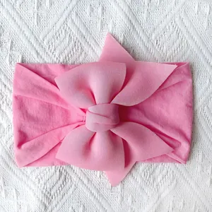 Detail van roze zachte nylon baby hoofdband met een gelaagde getextureerde strik