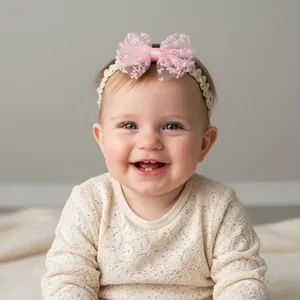 Detail of baby girl headband featuring light pink lace bow and floral embroidery