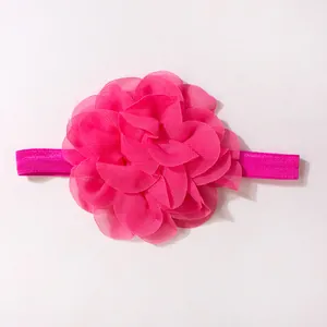 Dettaglio macro di un fiore in chiffon rosa su fascia elastica per neonati
