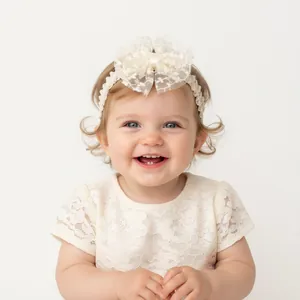 Detailed view of cream lace bow headband for baby girl baptisms and special events