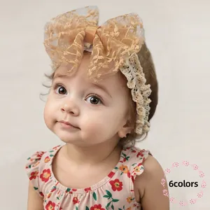 Detail of baby headband with oversized champagne lace bow and delicate floral embroidery