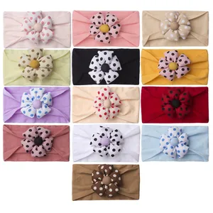 Set of 13 colorful baby headbands with polka dot flower accents on white background