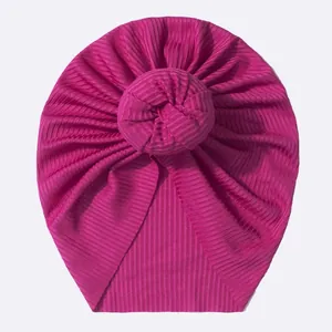 Détail du bonnet turban rose rouge en maille côtelée avec nœud donut pour nouveau-nés