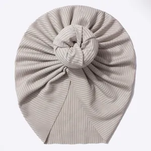 Vue détaillée du bonnet turban pour bébé en maille côtelée beige avec nœud 3D