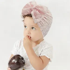 Close-up of pink bow knot on soft jacquard baby turban hat with breathable texture