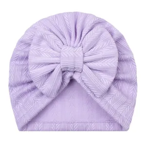 Détail du bonnet turban lilas pour bébé avec grand nœud et texture maille côtelée