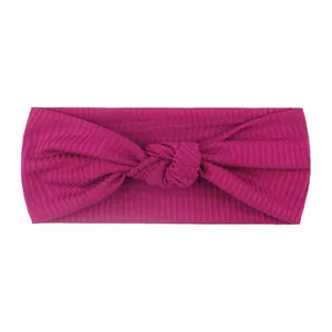 Dettaglio della fascia per neonati in maglia fucsia con design a nodo centrale