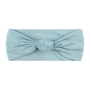 Dettaglio della fascia per neonati celeste in maglia a coste con nodo decorativo