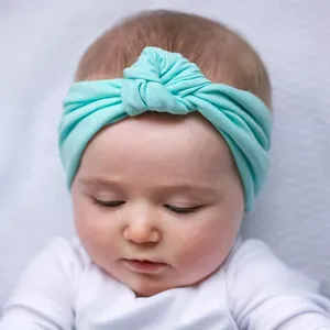 Detail of mint green knotted baby headband showing soft elastic knit texture