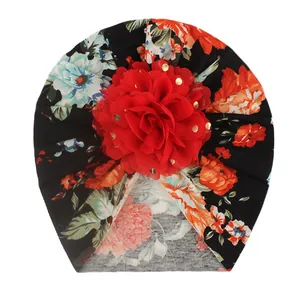 Detail of baby floral turban with a large red 3D flower and golden dot accents