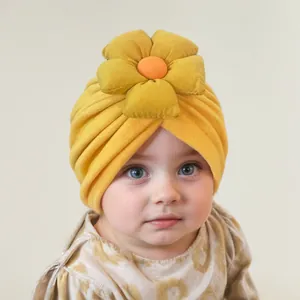 Close-up of yellow baby turban hat with a large 3D flower decoration and soft fabric