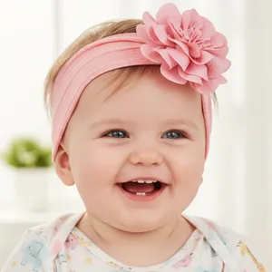 Gros plan d'un bébé portant un bandeau rose en nylon doux avec une grande fleur en tissu