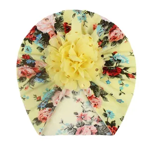 Detail of baby turban hat with golden foil flower print and mesh flower applique