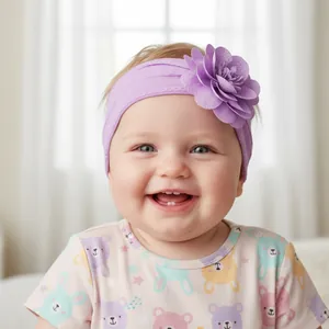 Gros plan d'un bébé portant un bandeau en nylon violet avec une fleur en tissu doux