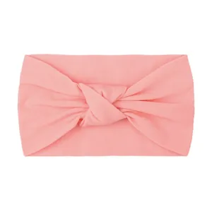 Detailed macro view of soft pink knotted nylon baby headband with wide ribbed fabric texture