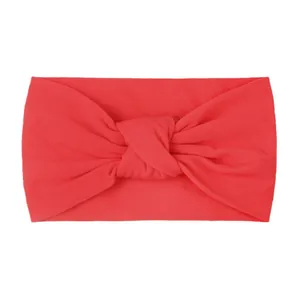 Detail of red knotted nylon headband for babies showing elastic fabric texture and twist
