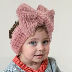 Gros plan d'un bandeau en peluche rose pour bébé avec un grand nœud décoratif doux