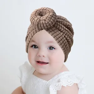 Close-up of baby donut turban hat featuring mocha brown waffle knit soft fabric