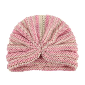 Dettaglio del turbante neonato con trama a maglia a righe rosa e beige e design con nodo