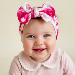 Détail du bandeau bébé tie-dye rose et blanc avec grand nœud sur modèle infantile