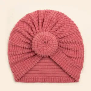 Pink donut baby turban hat made of soft waffle fabric with elastic ribbed knit texture