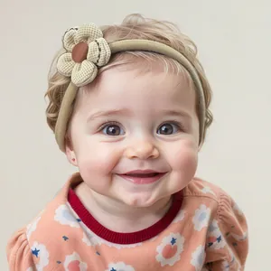 Close-up of baby girl wearing a soft beige fabric flower headband with delicate petals