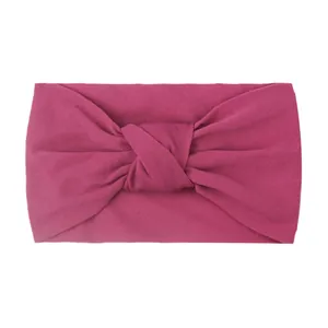 Macro detail of elastic magenta nylon baby headband with a wide twisted knot design