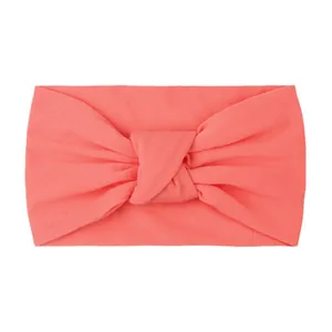 Close-up of coral pink knotted baby headband made of soft high-elastic fabric