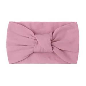 Close-up of soft baby pink nylon knotted headband showing high-quality fabric texture