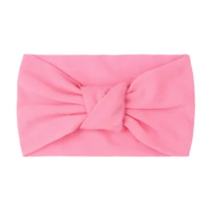 Detail showing the fabric texture and central knot design of the pink baby headband