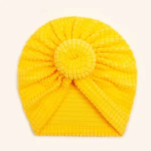 Detailed macro view of yellow waffle knit baby donut turban hat with soft elastic texture