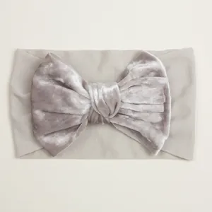 Détail du nœud en velours gris et bandeau large en nylon élastique pour bébé fille