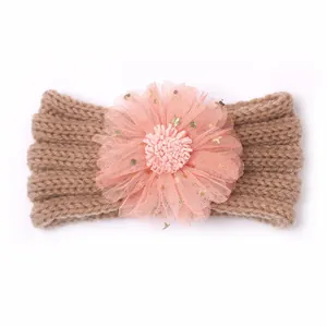 Détail du bandeau bébé tricoté marron avec fleur en dentelle rose et paillettes dorées