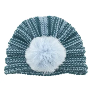 Close-up of baby knit hat featuring light blue vertical stripes and a soft pom-pom