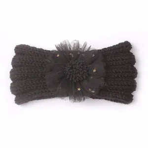 Détail d'un bandeau en tricot noir pour bébé avec fleurs en tulle et étoiles dorées